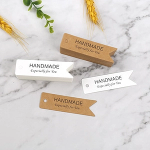Close-up of 'Handmade Especially for You' kraft and white paper swallowtail gift tags