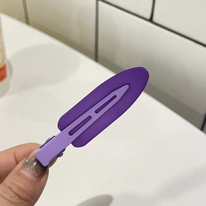 Close-up of a purple matte duckbill hair clip with a trendy two-tone color block design