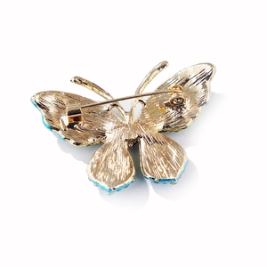 Detail view showing the golden back base and secure pin buckle of the butterfly brooch