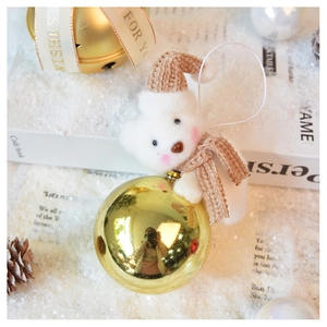 White plush Christmas bear ornament with brown hat, scarf and a shiny golden bauble detail