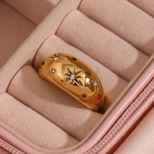 Macro view of gold-plated dome ring with colorful star-set gems in a pink jewelry box