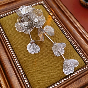 Detailed macro view of silver flower brooch with zircon stones and wire weave petals
