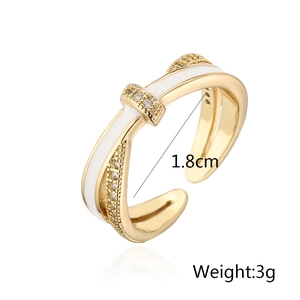 Detail of 18K gold plated cross ring with white enamel and sparkling zircon accents