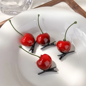 Set of four realistic red cherry hair clips made of glossy resin in a white ceramic bowl