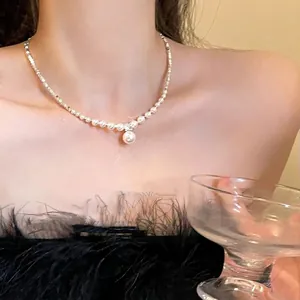 Détail d'un collier de perles plaqué or élégant avec un grand pendentif sur un mannequin