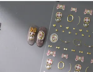 Macro detail of 3D nail stickers featuring red plaid circles and golden bow designs
