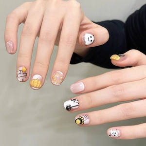 Halloween press-on nails featuring hand-painted ghost, pumpkin, and spider web art designs