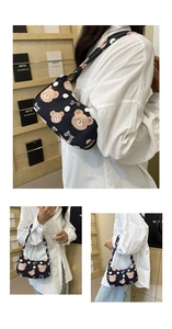Close-up of cute cartoon bear print on black crescent underarm bag with shoulder strap