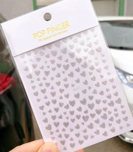 Macro shot of silver glitter heart 3D nail stickers Me017 with shiny finish effects