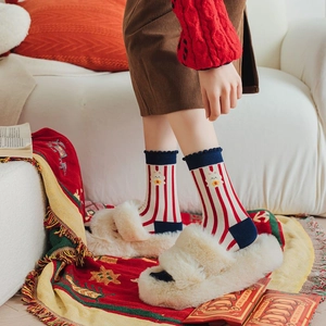 Detail of red and white striped socks with bunny print and blue ruffled cuff detail
