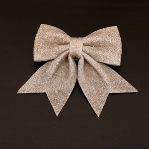 Rose gold sequined Christmas bow decoration for holiday trees on wooden background