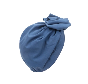 Detail of blue turban hat featuring a soft fabric texture and decorative floral knot design