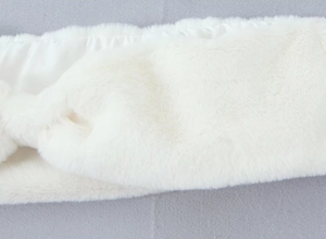 Gros plan sur la texture pelucheuse blanche et les détails en fausse fourrure du châle