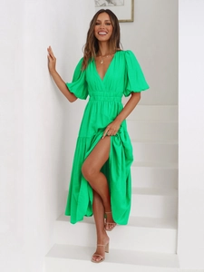 Detail of the deep V-neckline and puff sleeve texture on a bright green vacation maxi dress