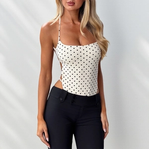 Détail d'un body blanc à pois avec de fines bretelles et un design dos nu sur mannequin