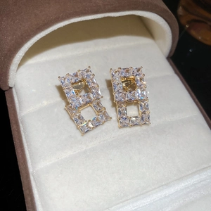 Macro shot of 18K gold plated square hollow earrings with cubic zirconia in a jewelry box