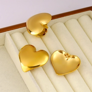 Macro shot of 18K gold plated heart ring and earrings set in a beige jewelry box