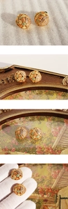 Macro shot of gold floral enamel earrings with sparkling cubic zirconia inlay details