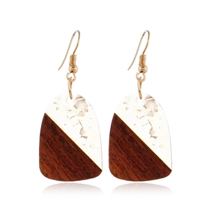 Detail of geometric resin and wood earrings with gold foil inlay on white background