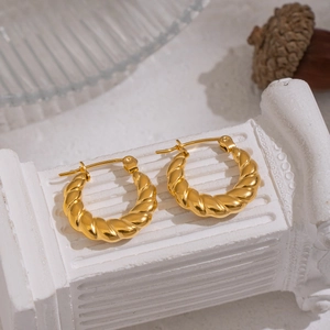 Elegant 18K gold-plated U-shaped twist hoop earrings displayed on a white marble pillar