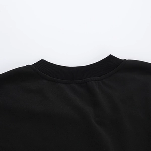Close-up of the ribbed crewneck collar and stitching on the black sweatshirt fabric