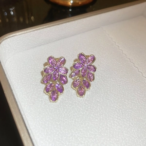 Detailansicht der violetten Blumenohrringe mit funkelnden Kristallen und Goldakzenten