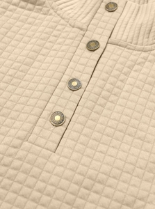 Detailed macro view of quilted waffle texture with ribbed collar and metallic buttons