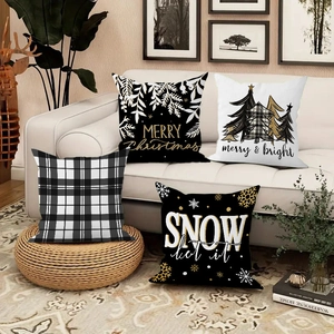 Detail of four Christmas linen pillowcases with trees and snowflakes on a white sofa