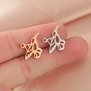 Polished stainless steel hummingbird charms in rose gold and silver finish shown on a finger