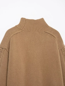 Dettaglio di maglione marrone a maglia grossa con collo a lupetto e texture morbida