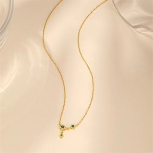 Detailed close-up of a gold S925 silver necklace featuring a green star pendant