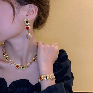 Close-up of vintage cameo necklace set with gold floral heart charms and pink portrait