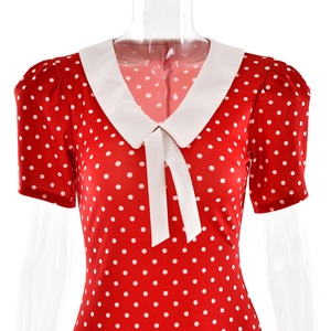 Close-up of red polka dot dress featuring a white Peter Pan collar and bow detail