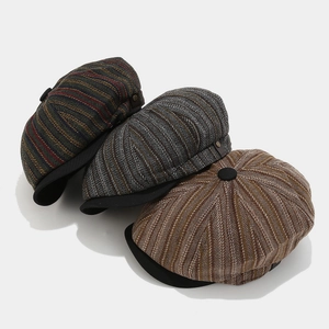 Detailed view of British style tweed baker boy hats in striped and herringbone patterns