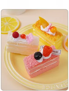 Detailansicht von drei realistischen Frucht-Mousse-Tortenmodellen auf einem Tablett