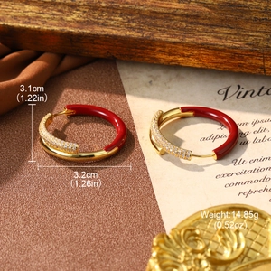 Detailed view of red enamel and gold earrings showing precise 3.1x3.2cm size and weight
