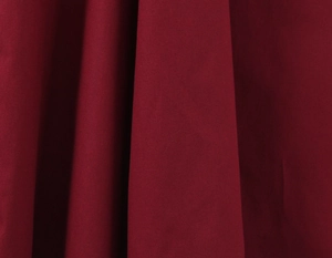 Vue macro détaillée du tissu rouge foncé montrant les drapés et la texture de qualité