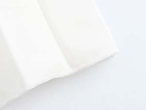 Nahaufnahme der feinen Overlock-Naht und hochwertigen weißen Plissee-Stoffdetails