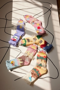 Close-up of five pairs of colorful coral fleece socks with cute bows and Sweet Mama tags