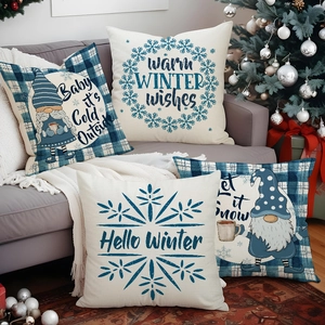 Set of four navy blue and cream linen Christmas pillow covers on a cozy grey sofa