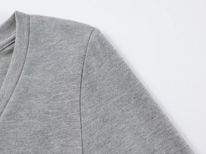 Détail de la couture du col en V et de la texture du tissu modal doux sur un T-shirt gris