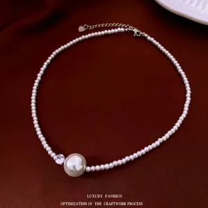 French pearl necklace with large center pearl and zircon on red velvet background