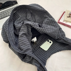 Detailed interior of dark grey plaid tote bag with zipper pocket and lifestyle accessories