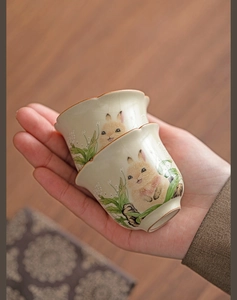 Macro detail of Ru ware ceramic tea cup with hand-painted rabbit and crackle glaze