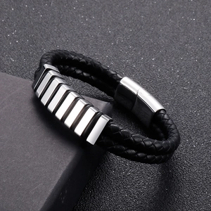 Macro detail of men's double-layer black braided leather bracelet with silver magnetic clasp