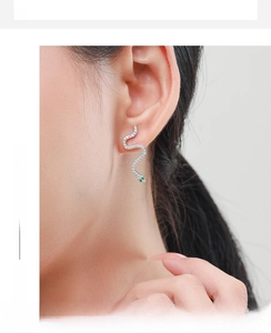 Close-up of S925 sterling silver snake earrings with white zircons and green gem eyes