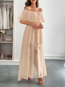 Dettaglio dell'elegante abito lungo beige a pois con spalle scoperte, tulle e laccio in vita
