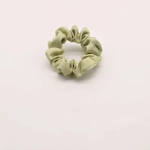 Dettaglio di un elastico in chiffon verde chiaro con trama di tessuto plissettato