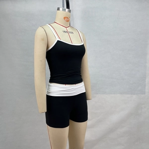 Close-up of contrast binding on the black camisole and slim fit athletic shorts set
