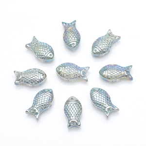 Macro detail of nine iridescent fish-shaped glass beads for DIY jewelry making